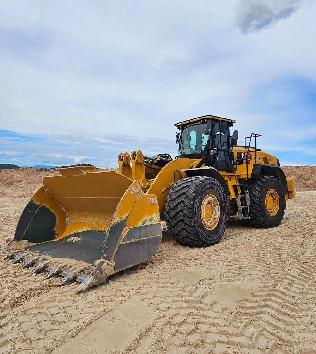 Heavy wheel loader with large bucket working on sandy jobsite